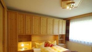 Ein Schlafzimmer mit Holzboden, einem Bett, Nachttischen und eingebauten Schränken.