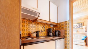 Eine kleine Küche mit Spüle, Kaffeemaschine und Toaster.