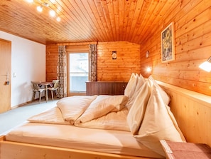 Une pièce de cabane en bois comprenant un lit, un bureau et une chaise.