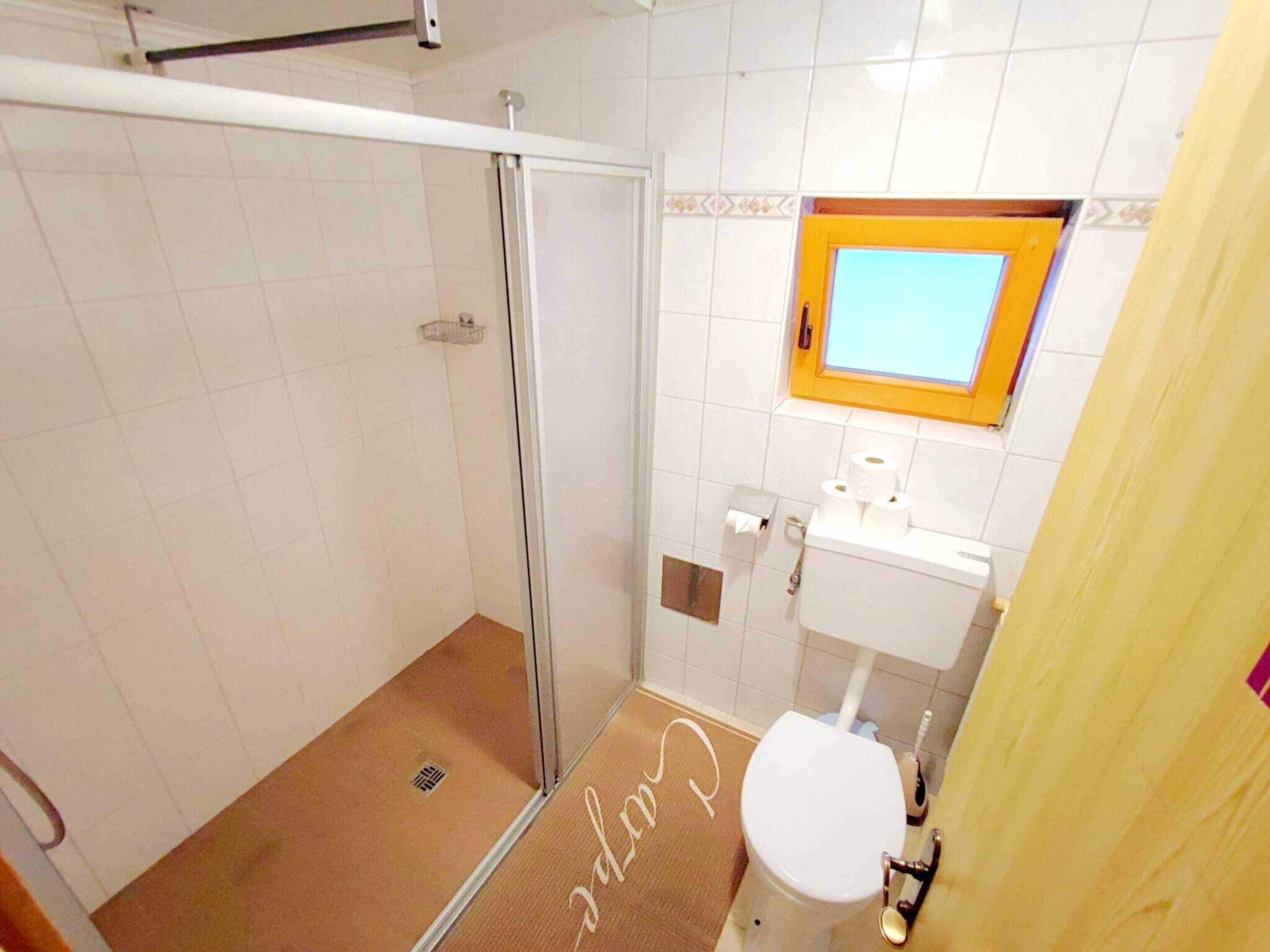 Un baño con ducha, inodoro y lavabo.