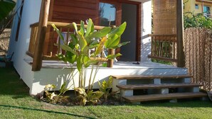 A two-story house with a balcony, wooden exterior, and a small garden area. - Casa Paula (Maraú)