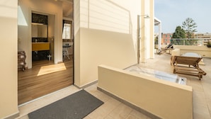 A modern apartment with a balcony, a wooden door, and a clear view of the sky. - Le Residenze di Carlà (Cagliari)