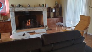 A living room with a fireplace, a sofa, a coffee table, and a chair. - South-facing detached house with private pool (Puy-l'Évêque)