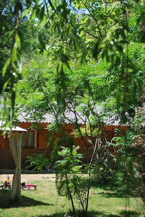 A wooden cabin with a small porch and a bicycle.
