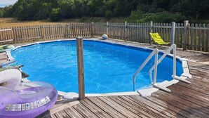 A rectangular swimming pool with a wooden deck and a wooden fence surrounding it. - Les Cigales II (Lamothe-Fénelon)