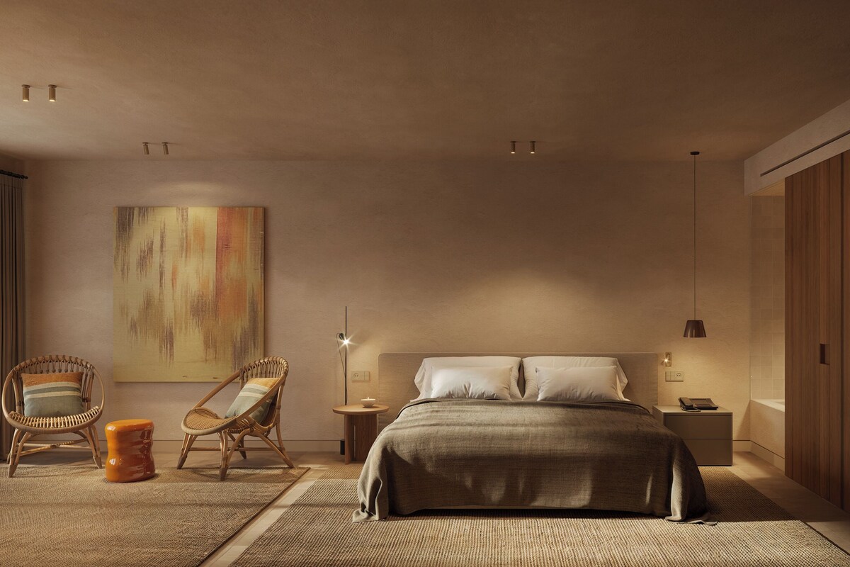 A bedroom with a bed, two chairs, a nightstand, a lamp, and a large painting on the wall.