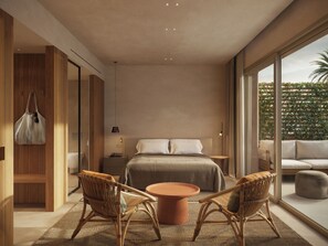 Un dormitorio moderno con una cama grande, dos sillas de mimbre, una mesita redonda y vistas a zonas verdes a través de amplias ventanas.