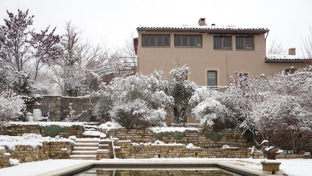 A snow-covered garden with a stone wall and a pool reflecting the surrounding trees. - In the heart of the Grand Luberon, a SWIMMING POOL, a QUIET, comfortable home. (Castellet-en-Luberon)