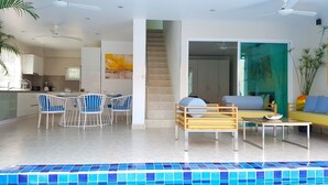Un área interior de piscina moderna con comedor y asientos.