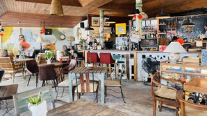 Un interior rústico con muebles de madera, una zona de bar y varios objetos decorativos.