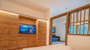 A bedroom with a wooden wardrobe, a television, and a window with a view of the outdoors. - Apartment in Neustift Near Ski Lift (Neustift Im Stubaital)