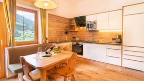 A modern kitchen with wooden cabinets, a built-in oven, and a microwave. - Apartment in Neustift Near Ski Lift (Neustift Im Stubaital)