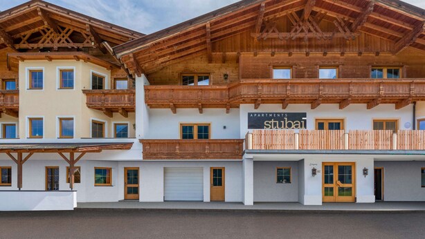 A multi-story building with wooden balconies and a sign reading "APARTMENTS stuba". - Holiday Apartment in Stubai With Balcony (Neustift Im Stubaital)