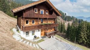 A wooden chalet with a balcony, set against a mountainous backdrop. - Spacious Holiday Home With Sauna (Fuegenberg)