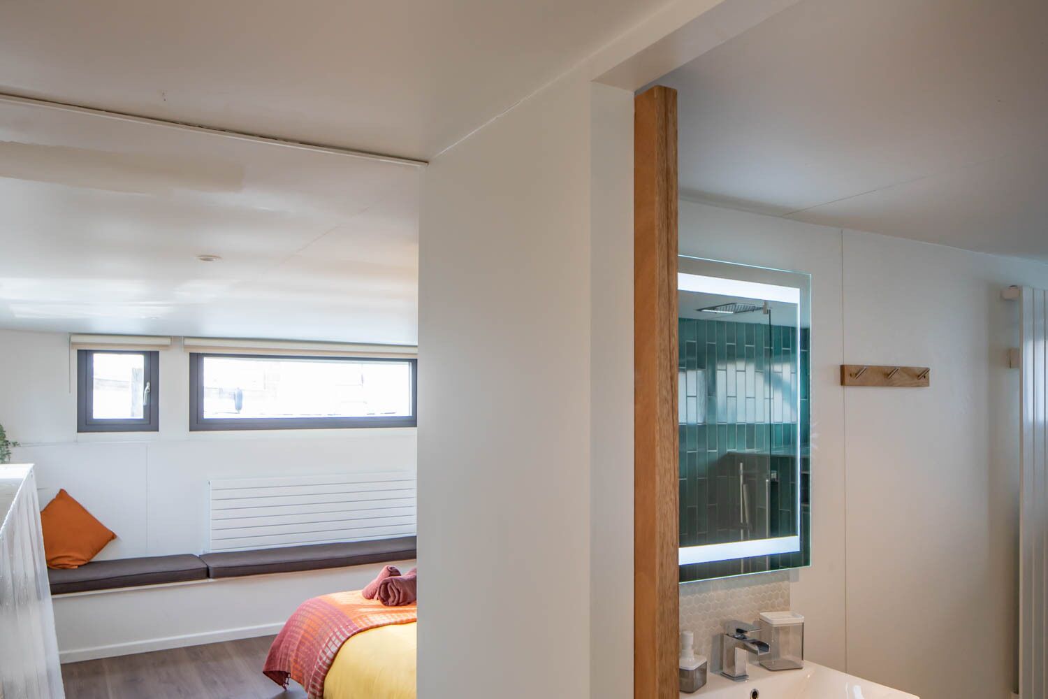 A modern bathroom with a large mirror, a sink, and a shower area.