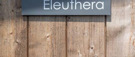 Un letrero con el número 4 y la palabra 'Eleuthera' sobre un fondo de madera.