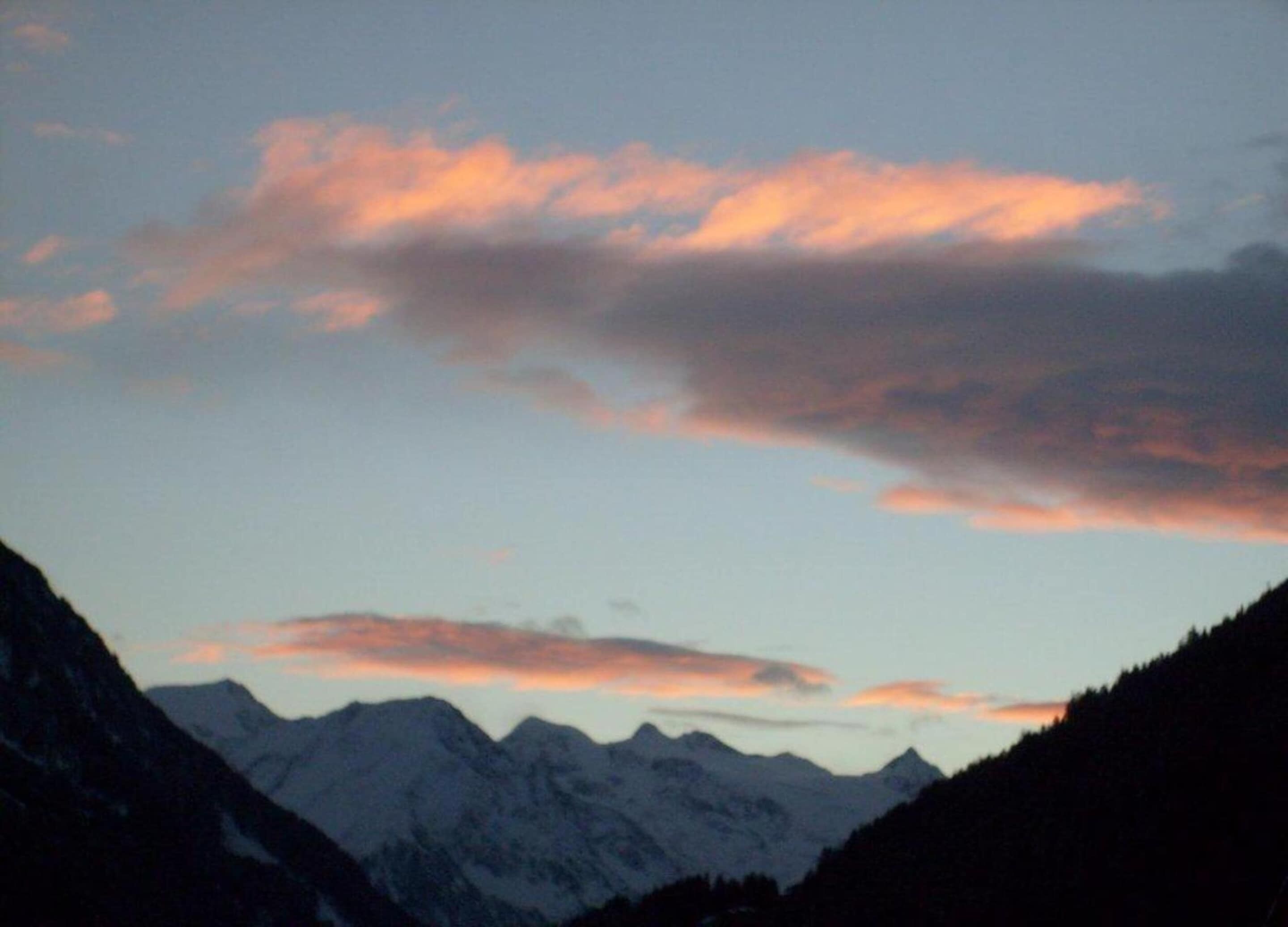 A mountain range with a clear sky and some clouds.