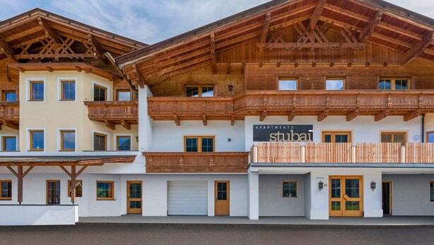 A multi-story hotel with wooden balconies and a sign reading "APARTMENTS Stuba". - Apartment Neustift Near Stubai Ski Lift (Neustift Im Stubaital)