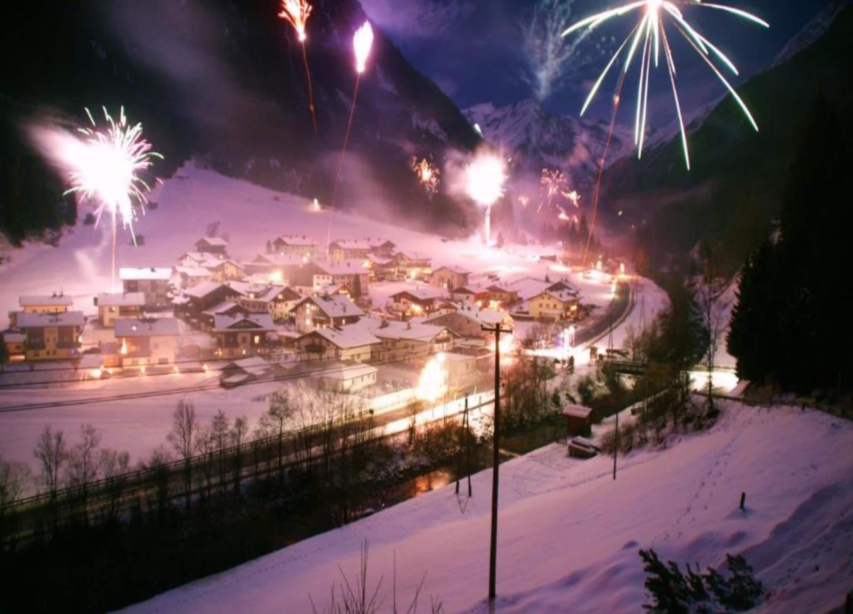 A snow-covered village with houses and a winding road.