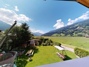Vista d'un pati amb un joc de balancà s'hi inclou, una barbacoa i una petita caseta.