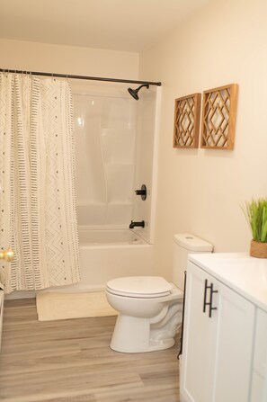 A bathroom with a shower, toilet, and sink.
