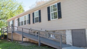 A two-story building with a wooden deck leading to the entrance.