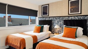 Ett hotellrum med två sängar, ett stort fönster och en taklampa.