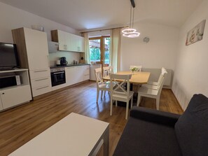 A compact living space with a kitchenette, dining area, and seating.