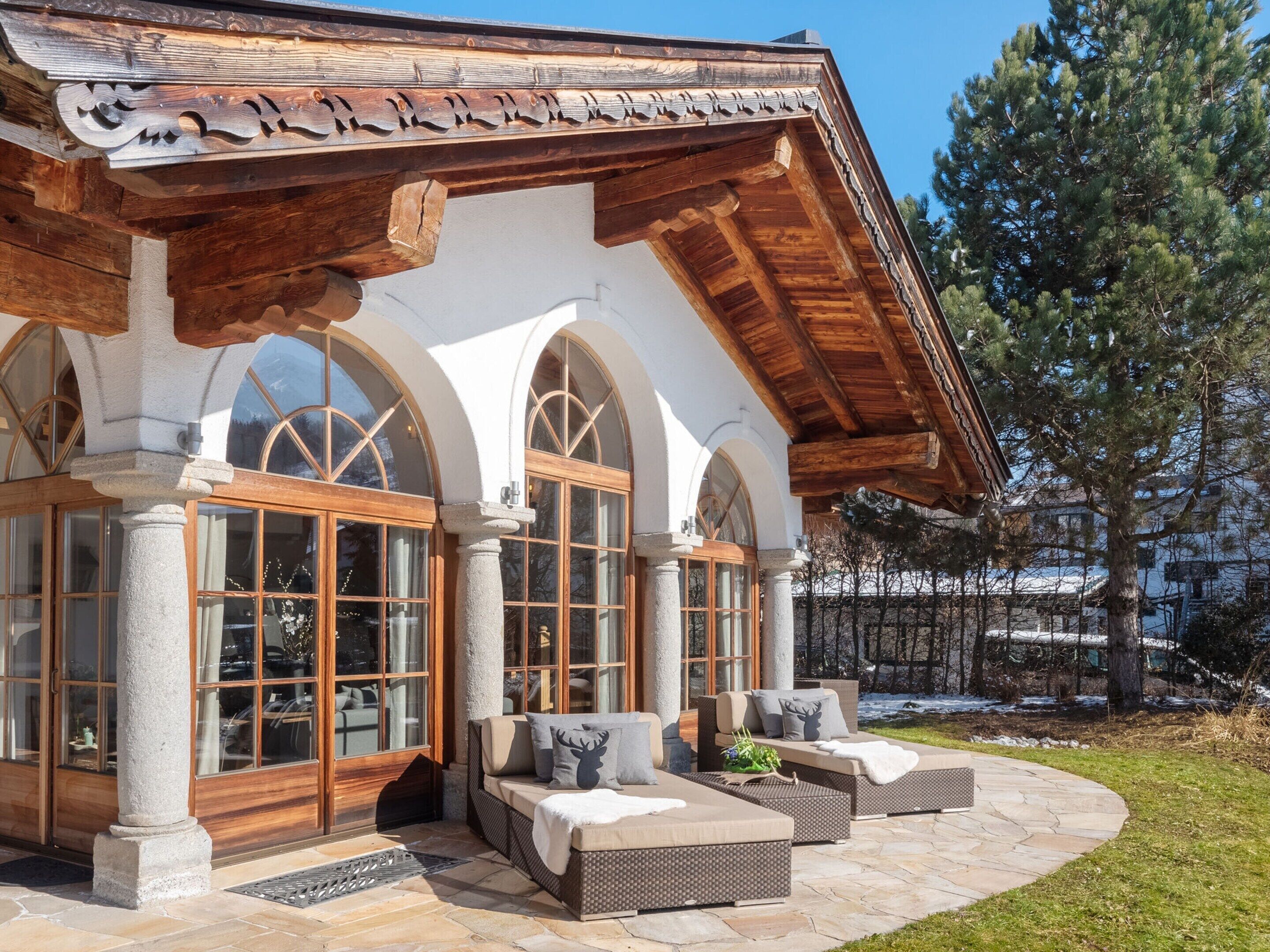 A lodge with a stone facade, wooden beams, and large arched windows.