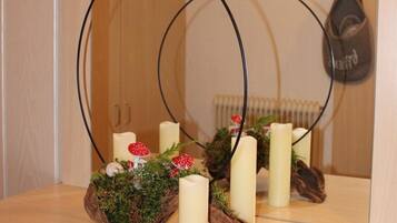 Un espejo que refleja un arreglo decorativo con velas y un centro de setas.