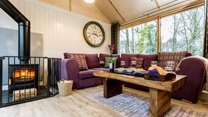 A cozy living room with a fireplace, a wooden coffee table, and a sofa set. - Lodge 19 (Wareham)