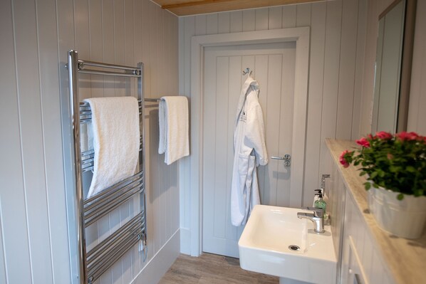 A bathroom with a white sink, a towel rack, and a door.