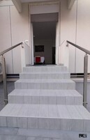 A set of marble stairs leading to an entrance with a closed shutter.