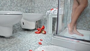A bathroom with a shower, a bidet, and a sink.