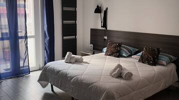 Un dormitorio moderno con una cama grande, mesitas de noche y un banco.