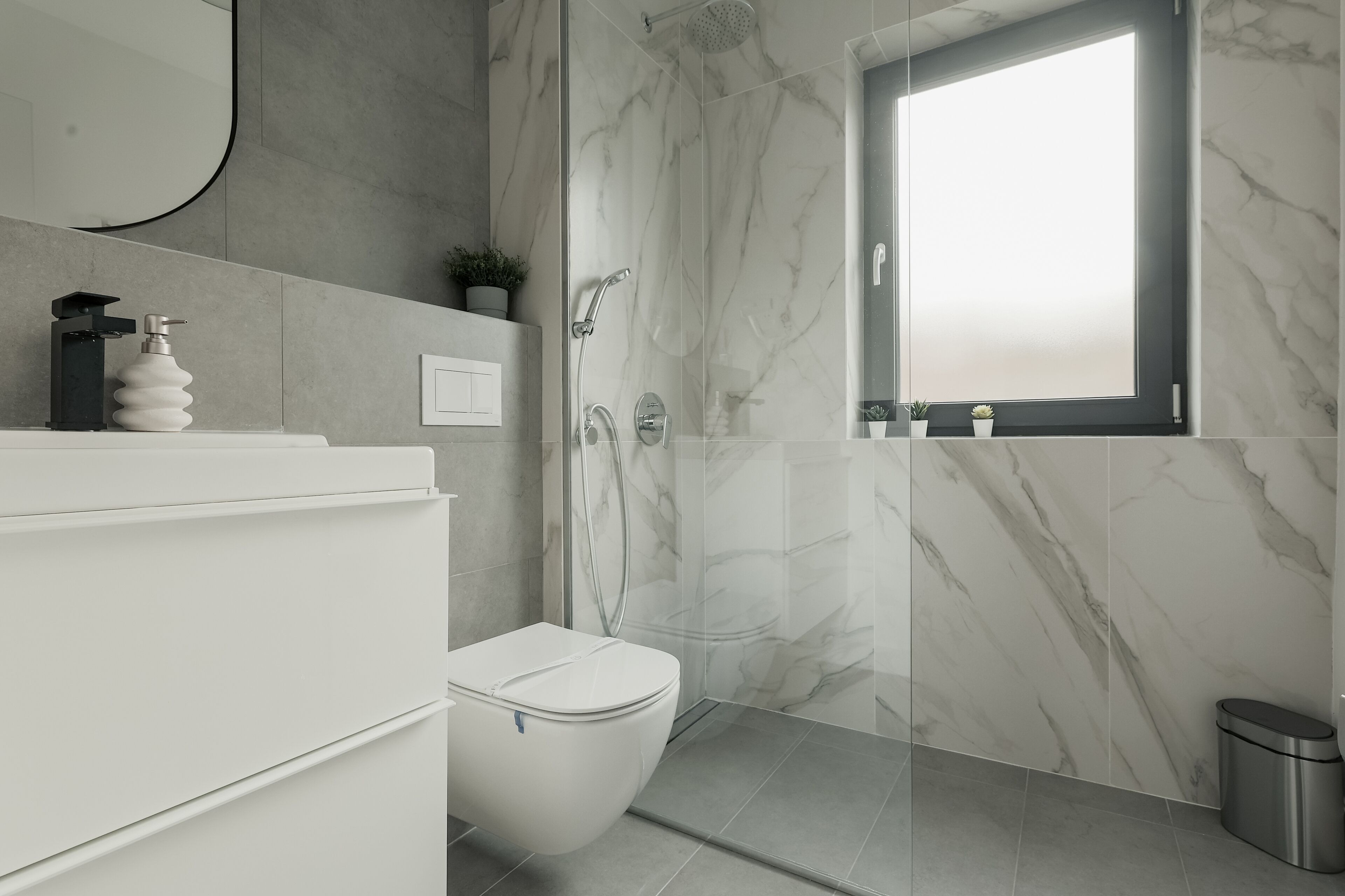 A modern bathroom with a toilet, sink, and shower area.
