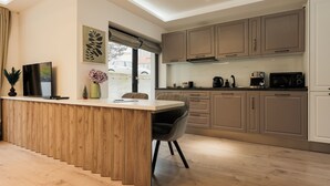 A modern kitchen with wooden cabinetry, a central island, and a dining area. - Nest Inn Meteor (Cluj-Napoca)