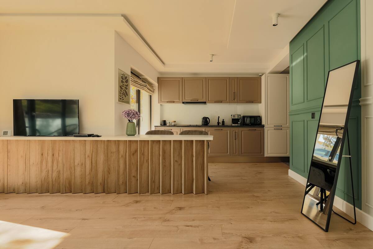 A modern kitchen with wooden cabinets, a central island, and a dining area.