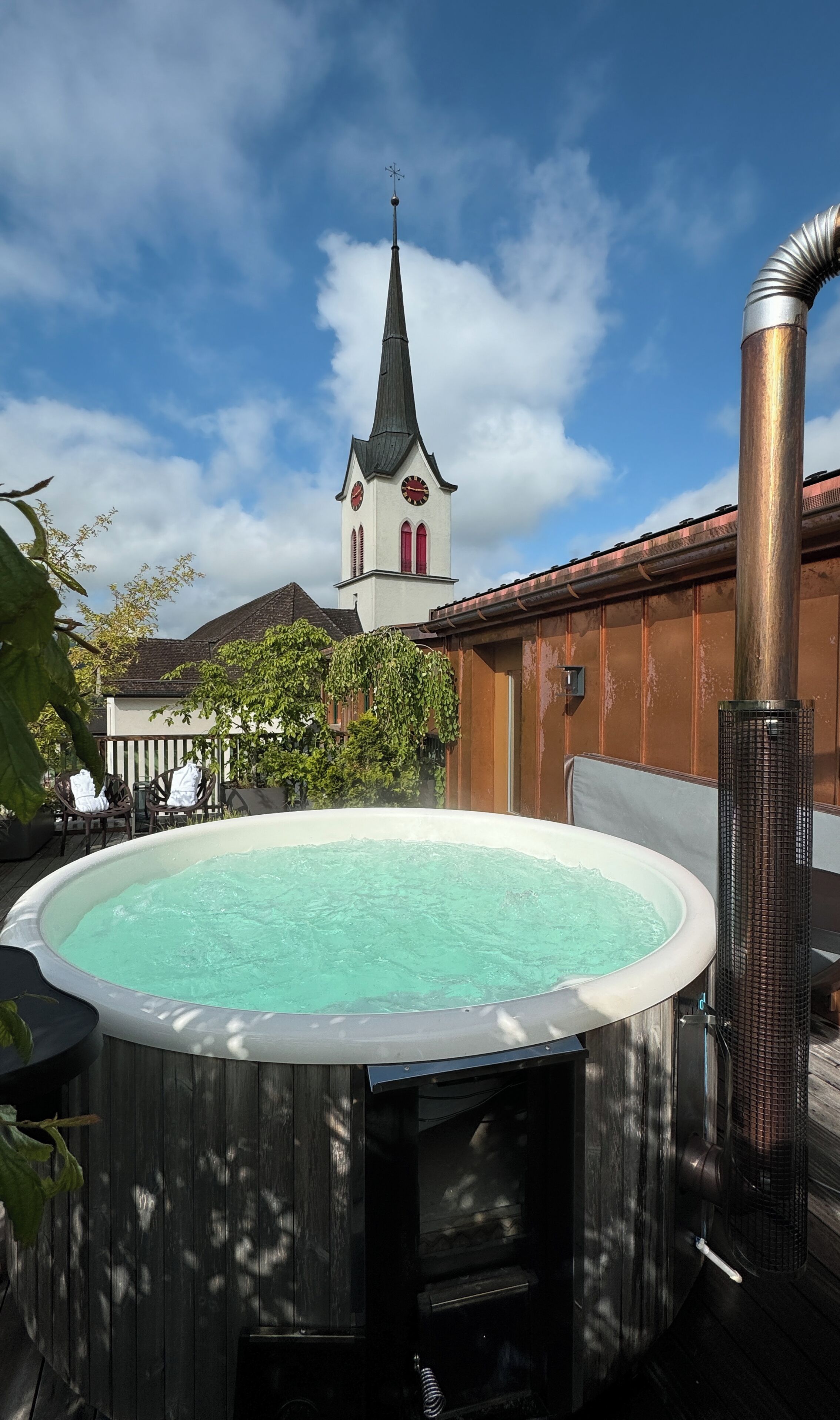 Un bain à remous avec vue sur le clocher d’une église en arrière-plan.