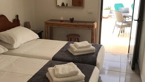 A hotel room with two beds, a wooden desk, a chair, and a view of the outside. - 1 BED APARTMENT IN THE HEART OF LAS AMERICAS, POOL & WI-FI (Playa Delas Americas)
