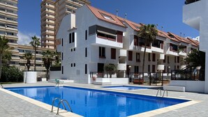A swimming pool with a clear blue water surface, surrounded by a tiled deck. - 1 BED APARTMENT IN THE HEART OF LAS AMERICAS, POOL & WI-FI (Playa Delas Americas)