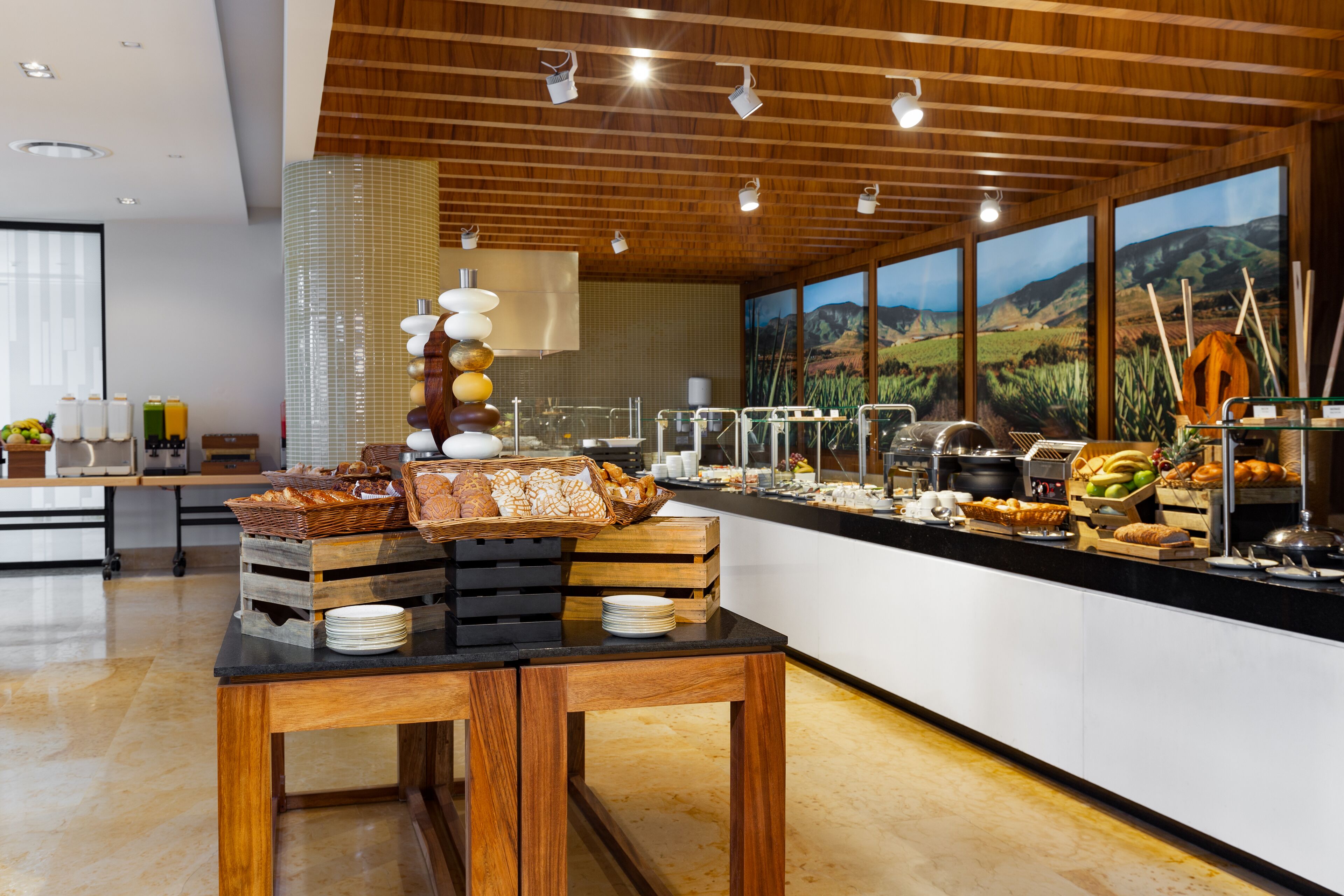 A buffet setup with various food items and a wooden table in a modern kitchen area.