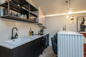 A modern kitchen with a white countertop, black cabinetry, and a built-in microwave.