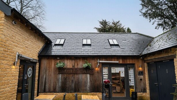 A rustic building with a wooden facade, a shop sign, and outdoor seating. - Chic Cotswold Tiny Home - Oddity House (Blockley)