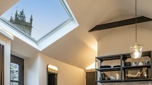 A modern interior with a skylight, a hallway leading to a door, and a kitchen area with a built-in shelf. - 🌿 Countryside Escape – Chic Tiny Home in the Heart of the Cotswolds (Blockley)