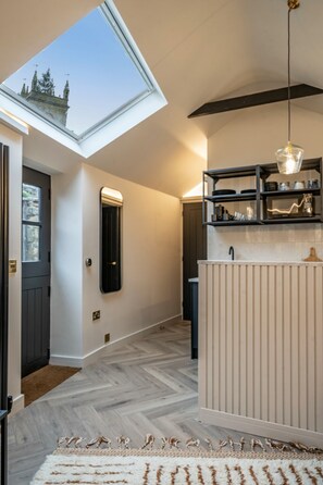 A modern interior with a skylight, a hallway leading to a door, and a kitchen area with a built-in shelf. - 🌿 Countryside Escape – Chic Tiny Home in the Heart of the Cotswolds (Blockley)