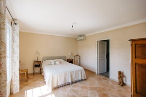 A bedroom with a bed, two bedside tables, a hanging lamp, a wardrobe, and a door. - Villa Balleti - private pool with a view (Apt)
