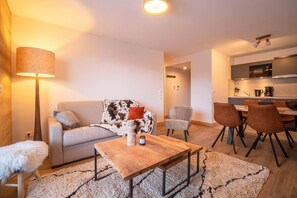 Una sala de estar moderna con un sofá, una mesa de centro y un comedor con sillas.