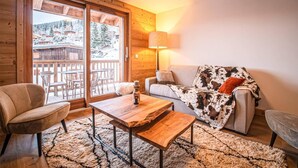 Une pièce chaleureuse avec un plancher en bois, un canapé, une table basse et une lampe.
