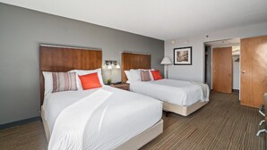 A hotel room with two beds, a wooden headboard, a framed picture on the wall, and a carpeted floor. - 315@Loso Hotel (Charlotte)